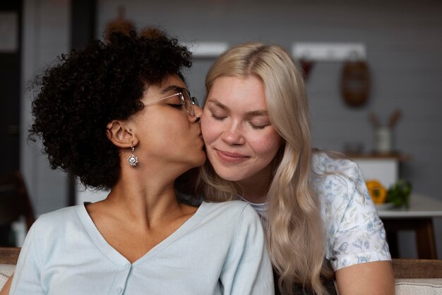 Donna che bacia la sua ragazza sulla guancia