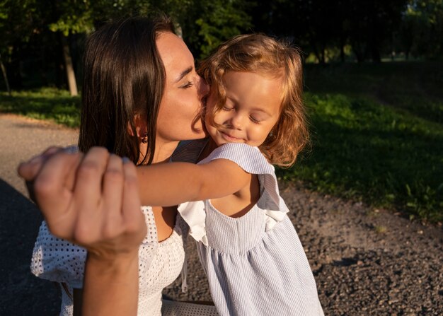 Donna che bacia ragazza sulla vista laterale della guancia