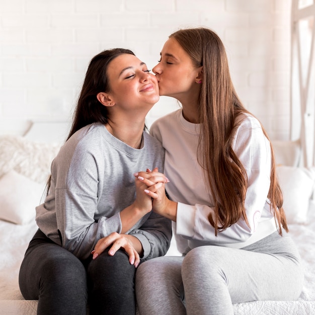 Donna che bacia un altro sul letto