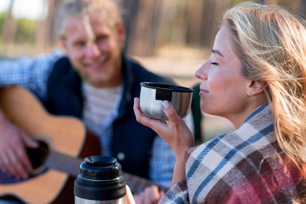 Donna che beve caffè sfocato uomo