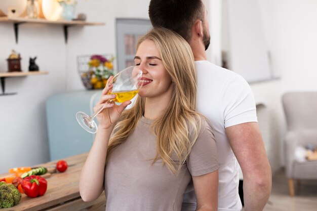 Donna che beve da un bicchiere schiena contro schiena suo uomo