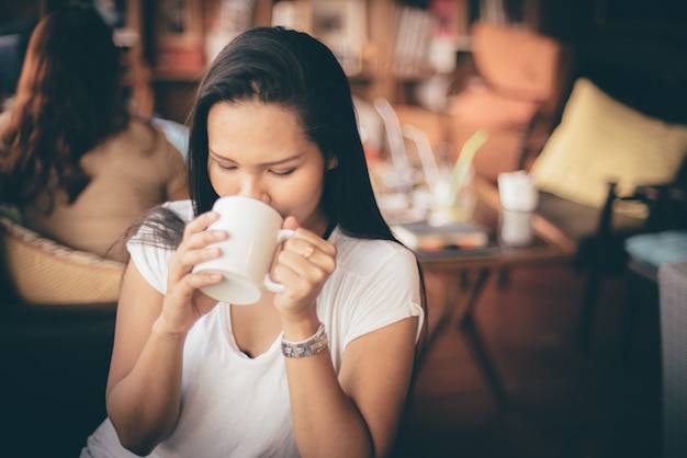 Donna che beve da una tazza di caffè