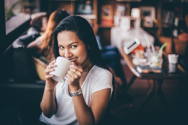 Donna che beve da una tazza di caffè