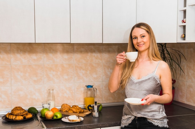 Donna che beve il caffè in cucina