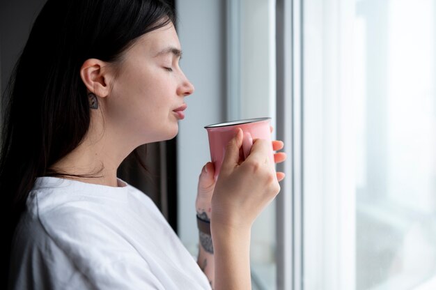 Donna che beve il tè a casa durante la quarantena