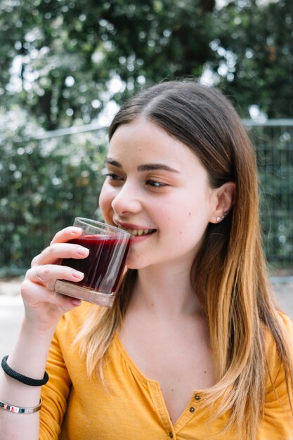 Donna che beve succo di melograno