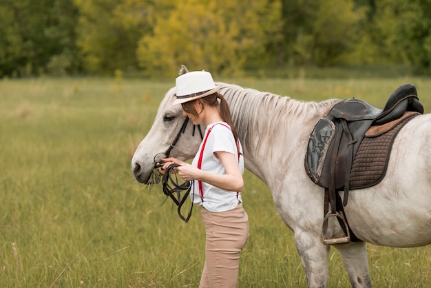 Donna che cammina con un cavallo in campagna