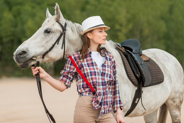 Donna che cammina con un cavallo in campagna