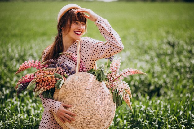 Donna che cammina in un campo con i lupini