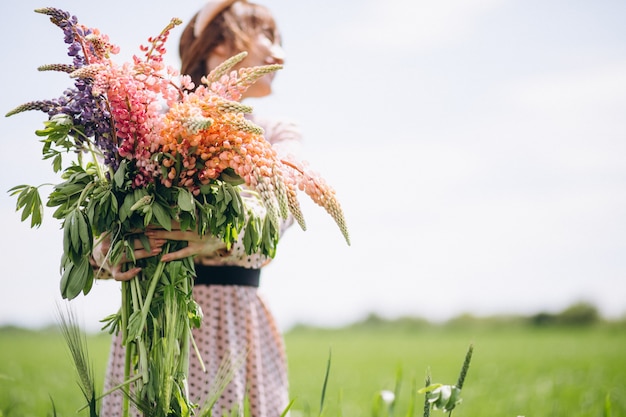 Donna che cammina in un campo con i lupini