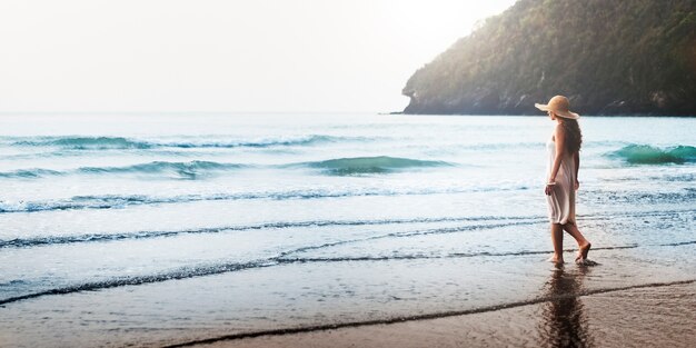 Donna che cammina lungo la spiaggia