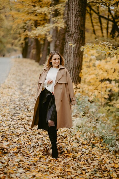 Donna che cammina nel parco d'autunno