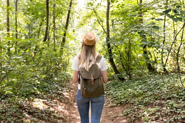 Donna che cammina nella foresta da dietro