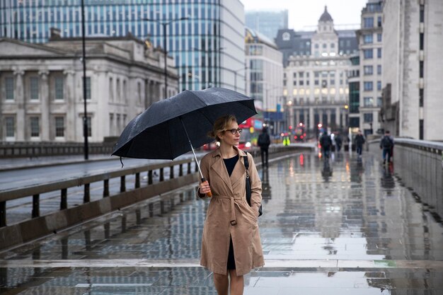 Donna che cammina per la città mentre piove
