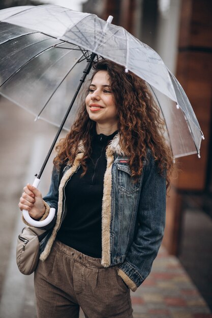 Donna che cammina sotto l'ombrello in un tempo piovoso