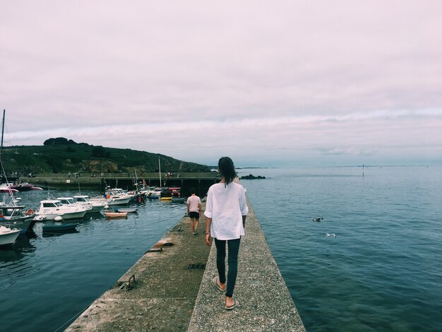 Donna che cammina su un sentiero in mezzo al mare