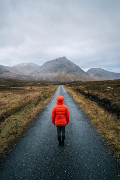 Donna che cammina su una strada a Glen Etive, Scozia