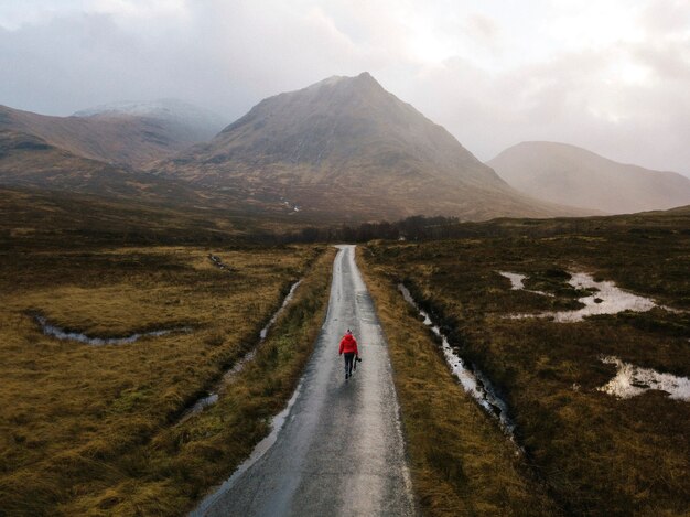 Donna che cammina su una strada a Glen Etive, Scozia