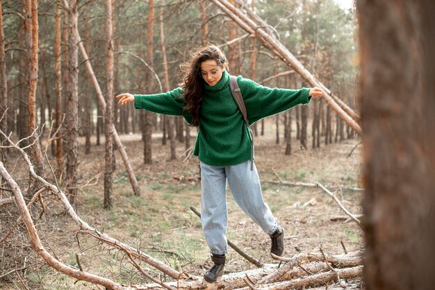 Donna che cammina sull'albero caduto