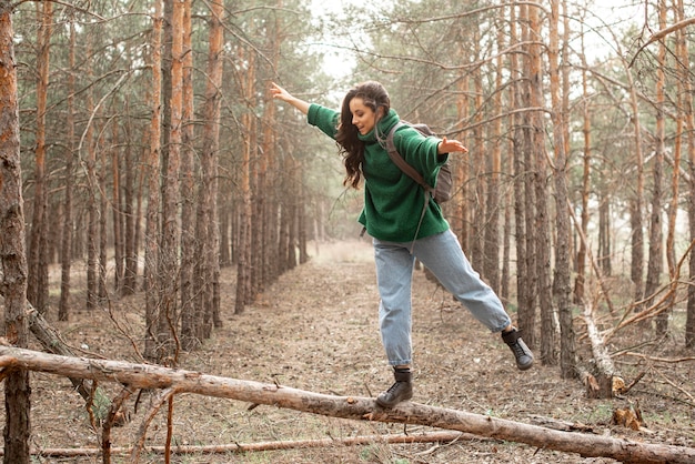 Donna che cammina sull'albero caduto