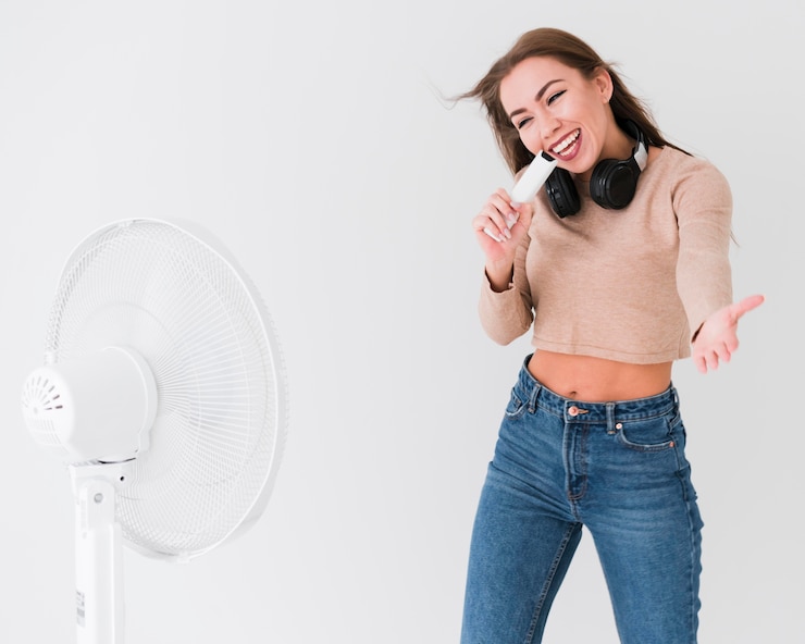 Foto gratuito donna che canta accanto a un fan aperto