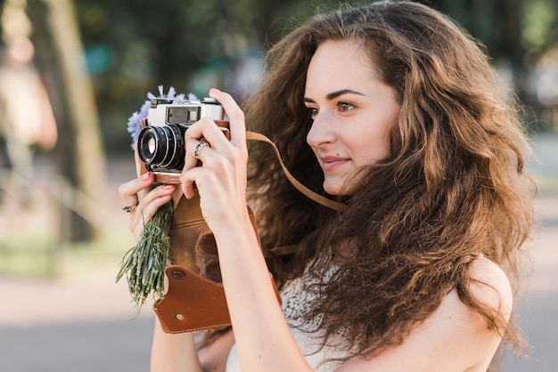 Donna che cattura maschera con la macchina fotografica