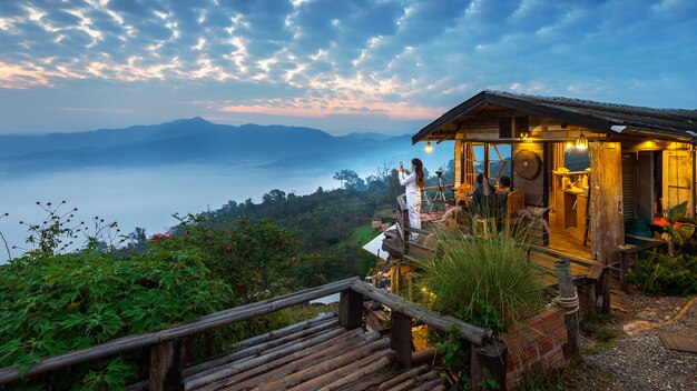 Donna che cattura una foto alla nebbia mattutina a Phu Lang Ka, Phayao in Thailandia.