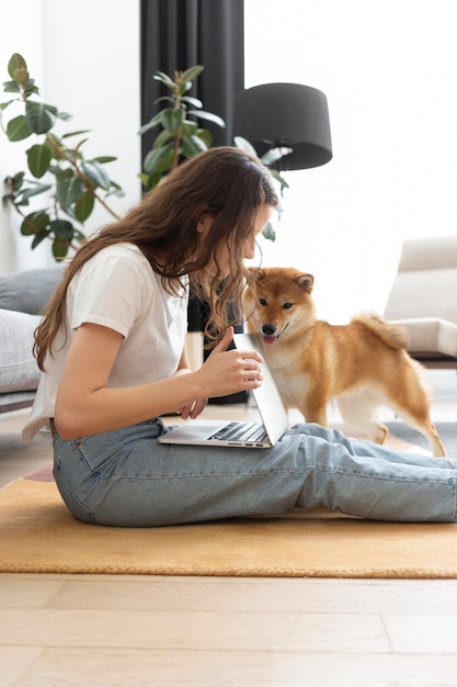 Donna che cerca di lavorare con il suo cane in giro