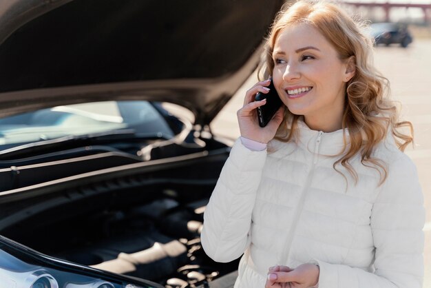 Donna che chiede aiuto per la sua auto