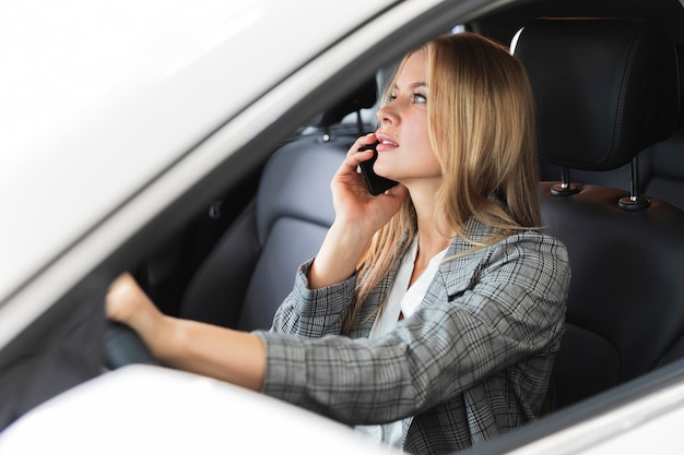 Donna che comunica sul telefono in auto