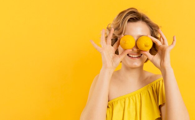 Donna che copre gli occhi di limoni