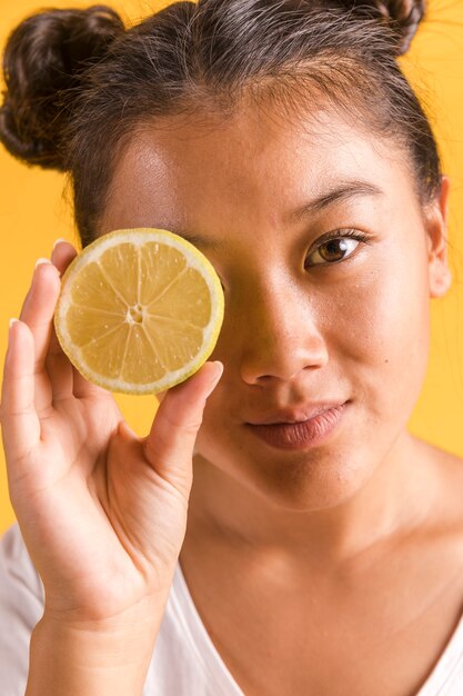 Donna che copre il suo occhio di limone