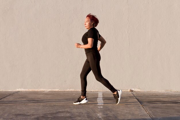 Donna che corre all'aperto colpo di vista laterale