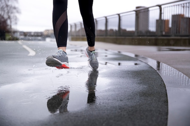 Donna che corre per le strade della città mentre piove