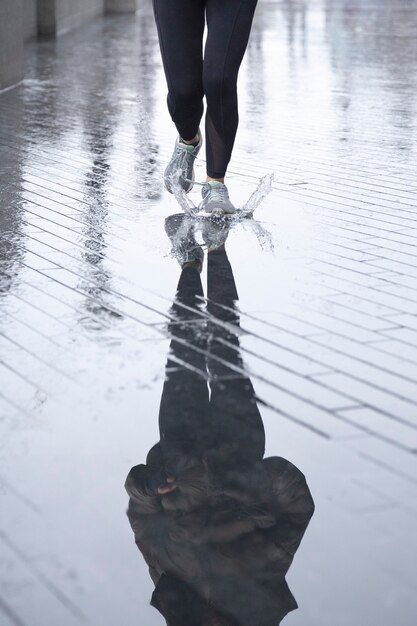 Donna che corre per le strade della città mentre piove