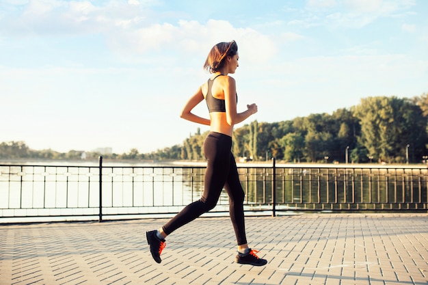 Donna che corre sul lago al tramonto