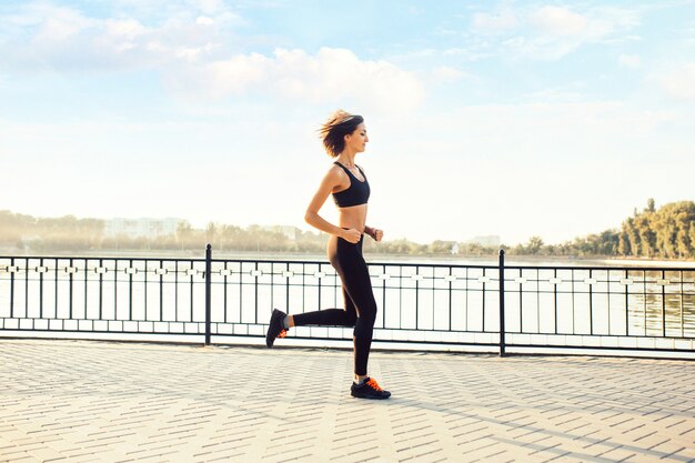 Donna che corre sul lago al tramonto