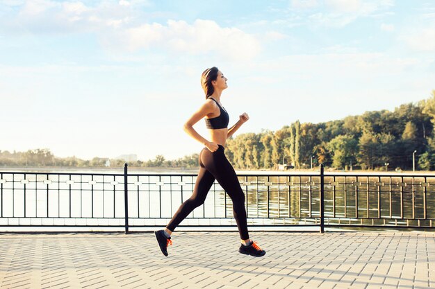 Donna che corre sul lago al tramonto