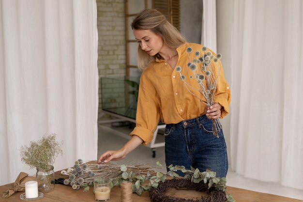 Donna che costruisce la propria composizione di fiori secchi