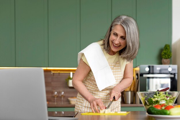 Donna che cucina in una cucina verde