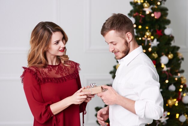 Donna che dà un regalo di Natale all'uomo