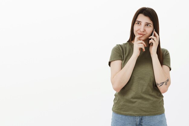 Donna che decide quale ordine parla con l'amministratore al telefono tenendo il dito sulle labbra mentre fa una scelta o una prenotazione