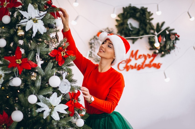 Donna che decora l&#39;albero di Natale