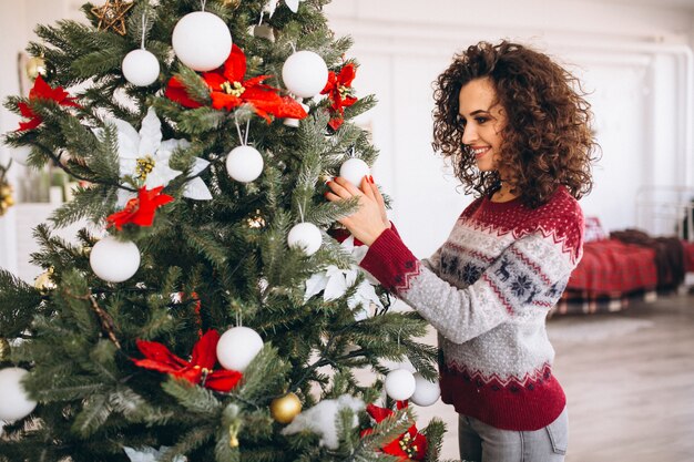 Donna che decora l&#39;albero di Natale