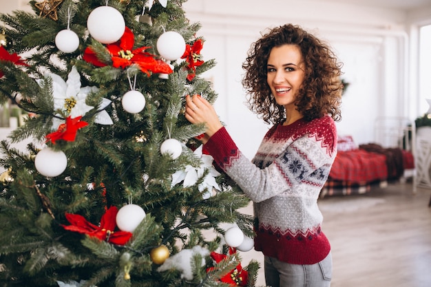 Donna che decora l&#39;albero di Natale