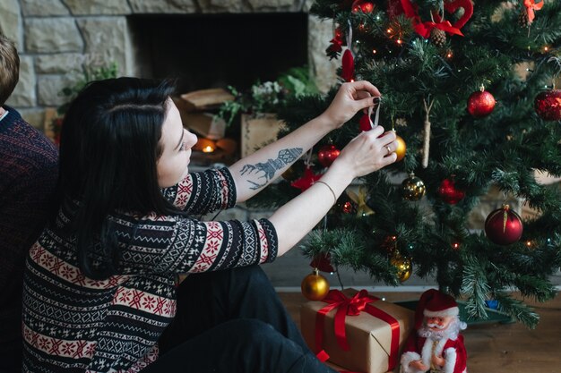 Donna che decora l&#39;albero di Natale