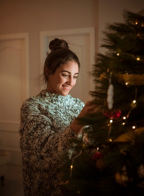 Donna che decora l&#39;albero di Natale