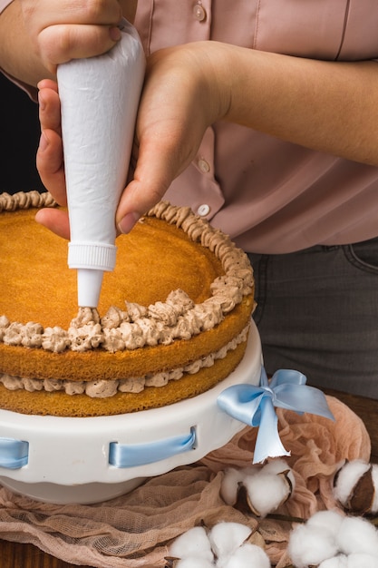 Donna che decora la torta fatta in casa