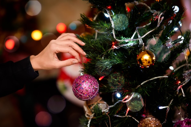 Donna che decora un albero di Natale