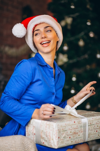 Donna che disimballa i regali dall&#39;albero di Natale